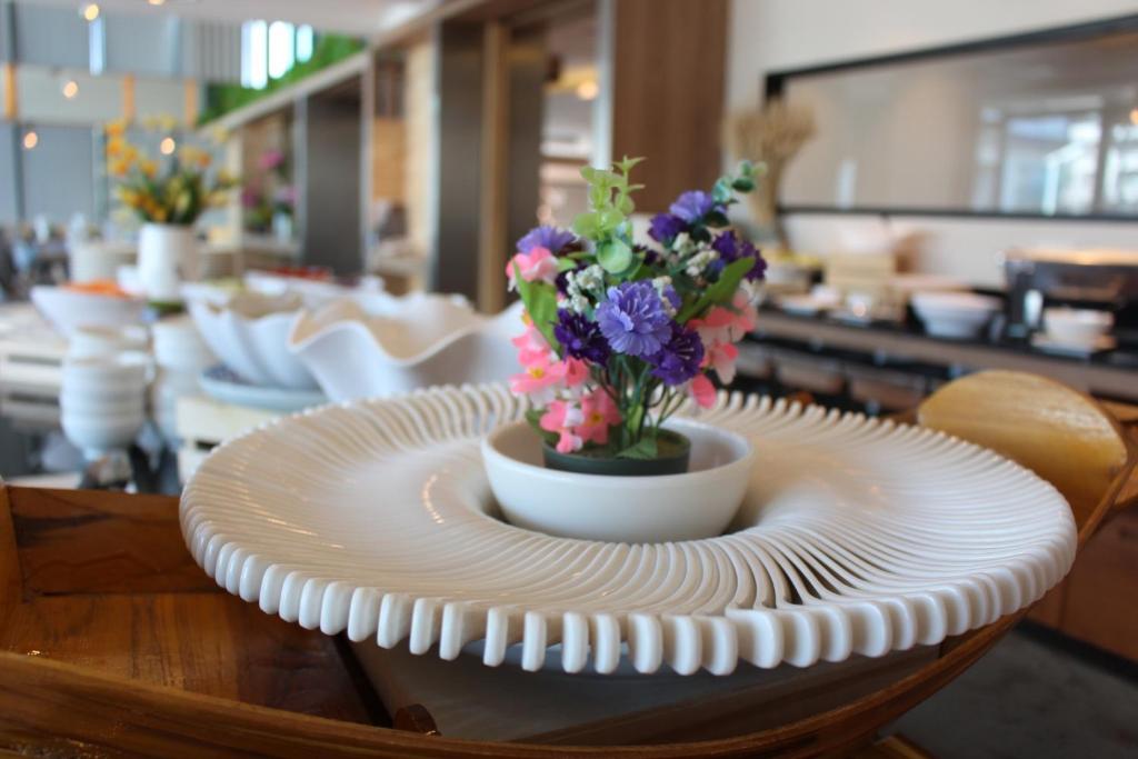 A styled floral centerpiece sits on a breakfast or dining table beside a buffet area.