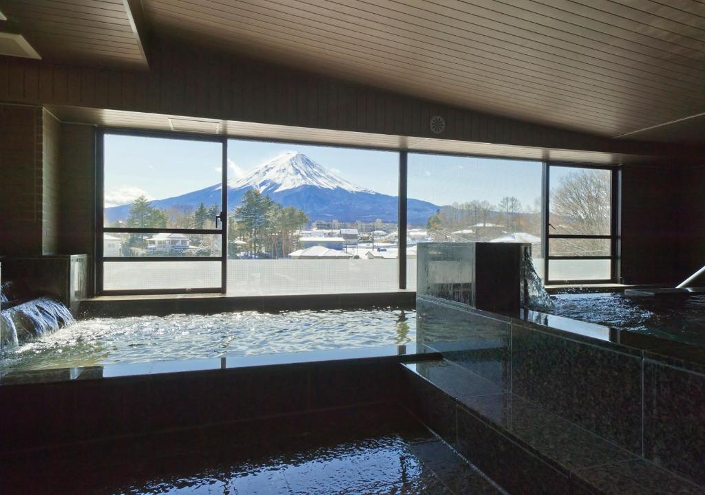 a swimming pool with a view of a snow covered mountain at Oike Hotel in Fujikawaguchiko