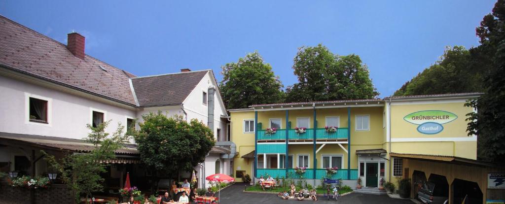 un grupo de edificios con gente sentada fuera de ellos en Gasthof Oberer Gesslbauer, en Stanz Im Murztal