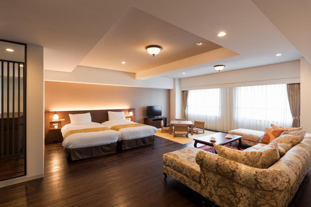 a hotel room with a bed and a couch at HAKODATE Uminokaze in Hakodate
