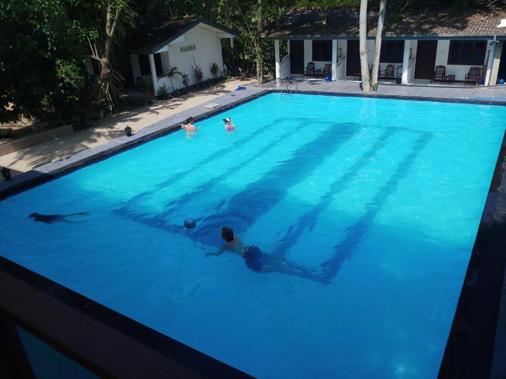 un grupo de personas nadando en una piscina en Jagabay Resort & Surfing School, en Weligama