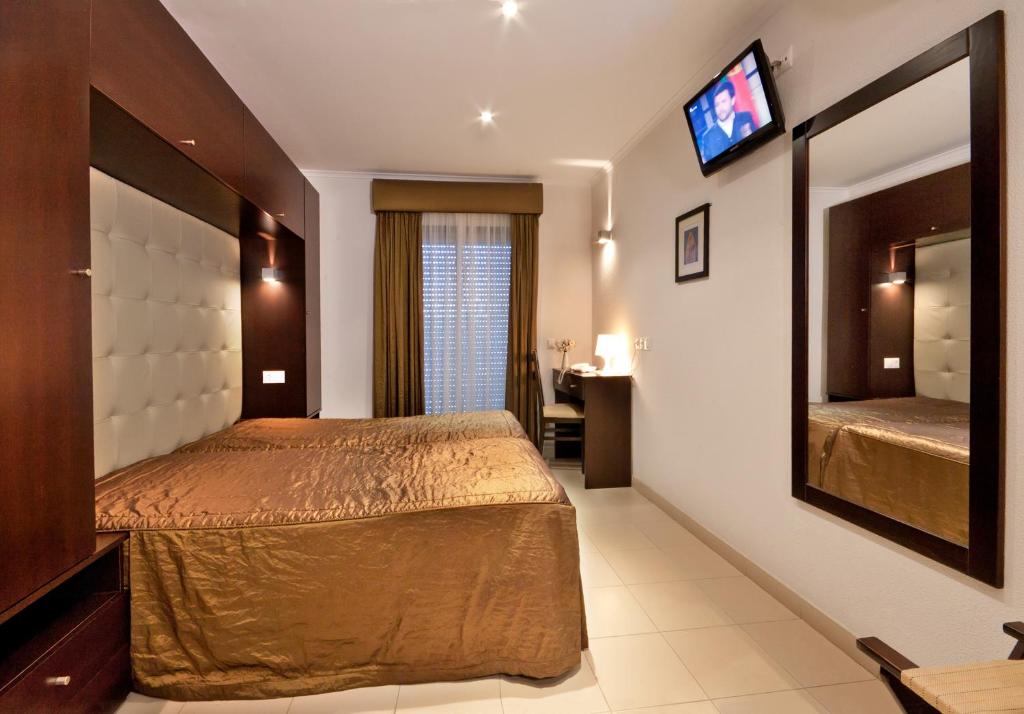 1 dormitorio con 1 cama grande y espejo en Residência S. Francisco, en Fátima