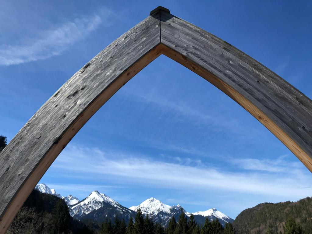 a wooden arch with mountains in the background at Bergmomente Neuschwanstein in Schwangau