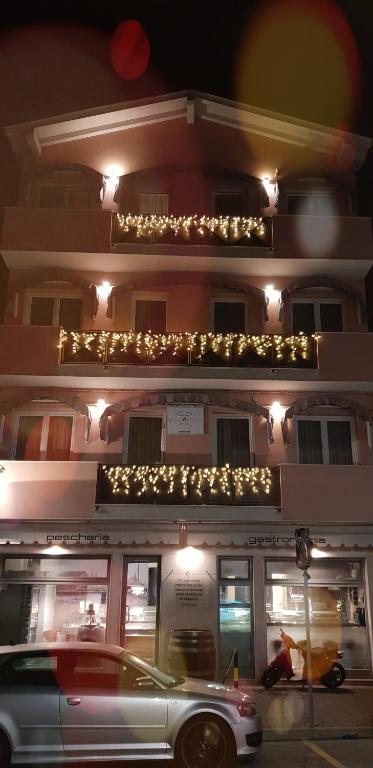 a white car parked in front of a building with lights at Casa Mafalda in Chioggia