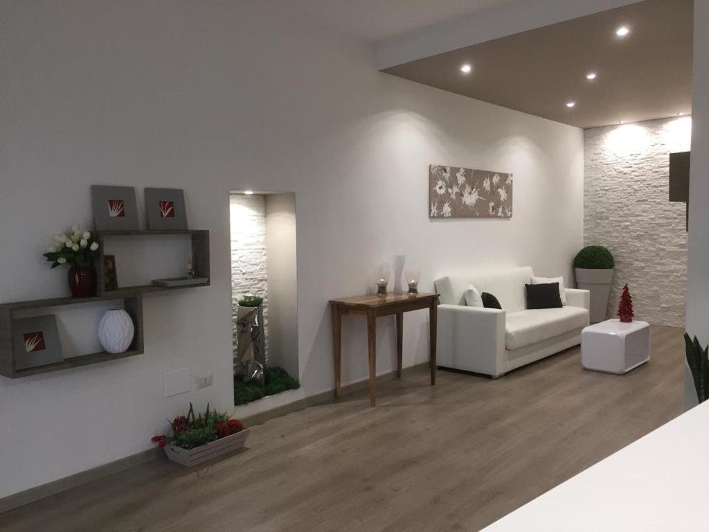 Le Antiche Vie في فيراندينا: غرفة معيشة مع أريكة بيضاء وطاولة