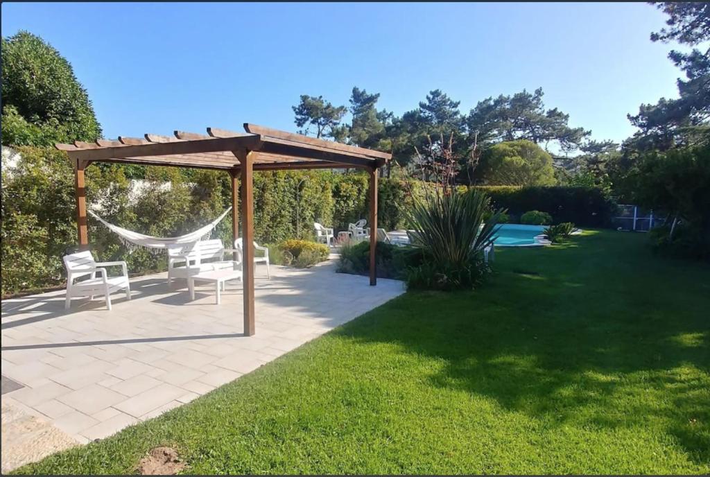 un cenador con 2 sillas y una hamaca en un patio en Casa Girassol with a beautiful private Pool and Garden en Sintra