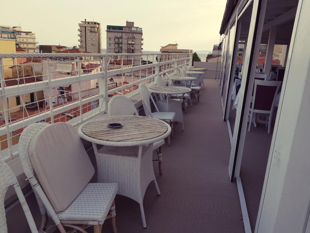 un balcone con tavoli e sedie su una nave da crociera di Hotel Bella 'Mbriana a Follonica