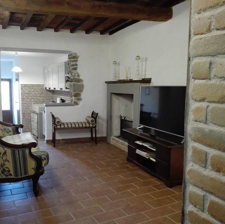 a living room with a television and a fireplace at La Torretta in Laterina