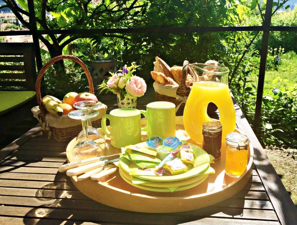 a picnic table with a plate of food and juice at Bed & Breakfast Chambres d'hôtes COTTAGE BELLEVUE in Cannes