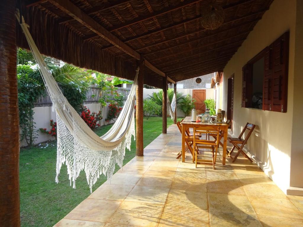 a patio with a hammock and a table and chairs at Os Navegantes B in Guajiru