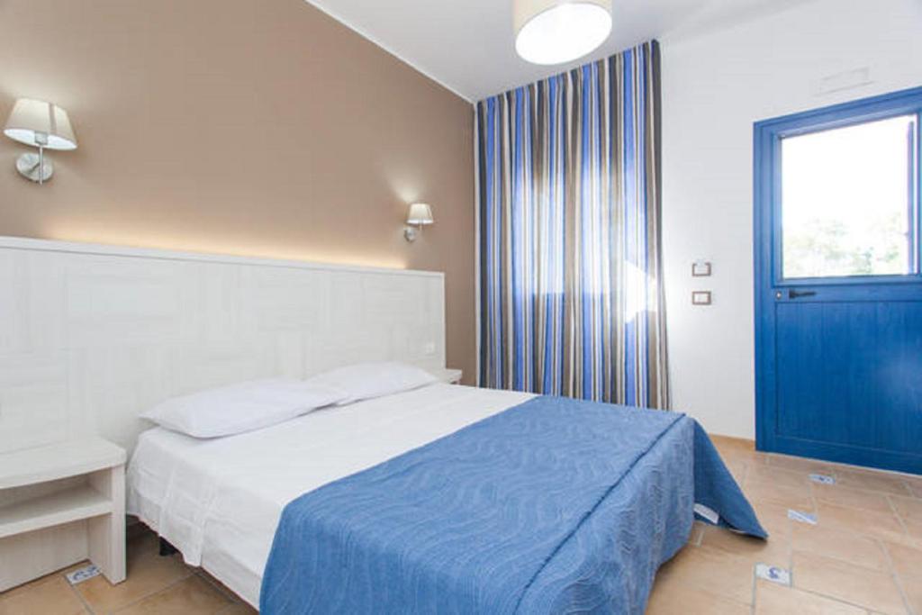 a bedroom with a bed and a blue door at Petruso Resort in Balestrate