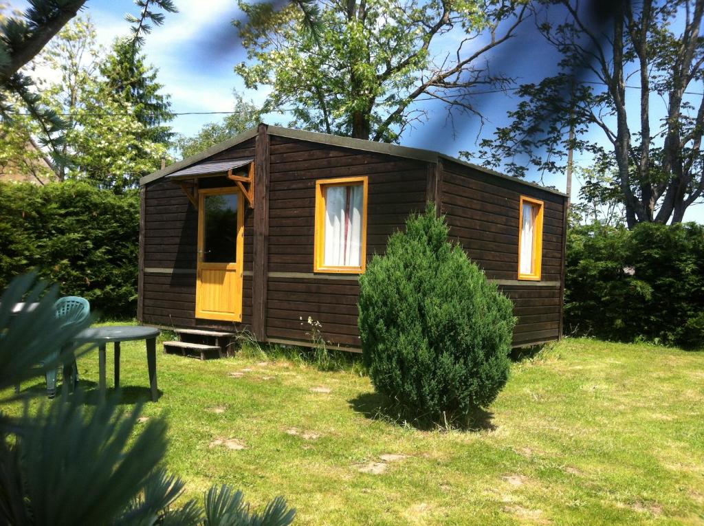 a small cabin in a yard with a bush at Domaine De Silvabelle in Mars-sur-Allier