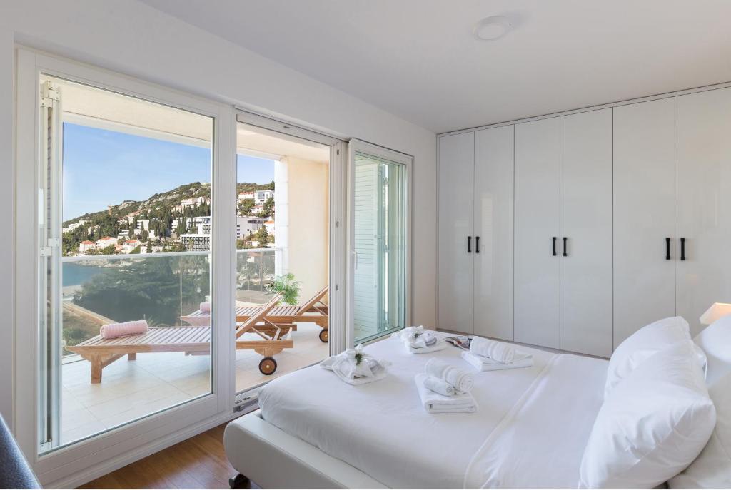 een slaapkamer met een bed en een balkon met uitzicht bij Apartments Nav in Dubrovnik