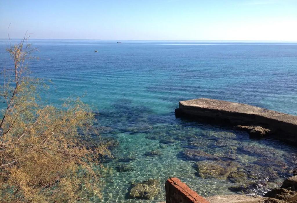 widok na ocean z kamieniami i wodą w obiekcie Villa Agave - SeaFront - Pool Kids - BBQ w mieście Santa Flavia