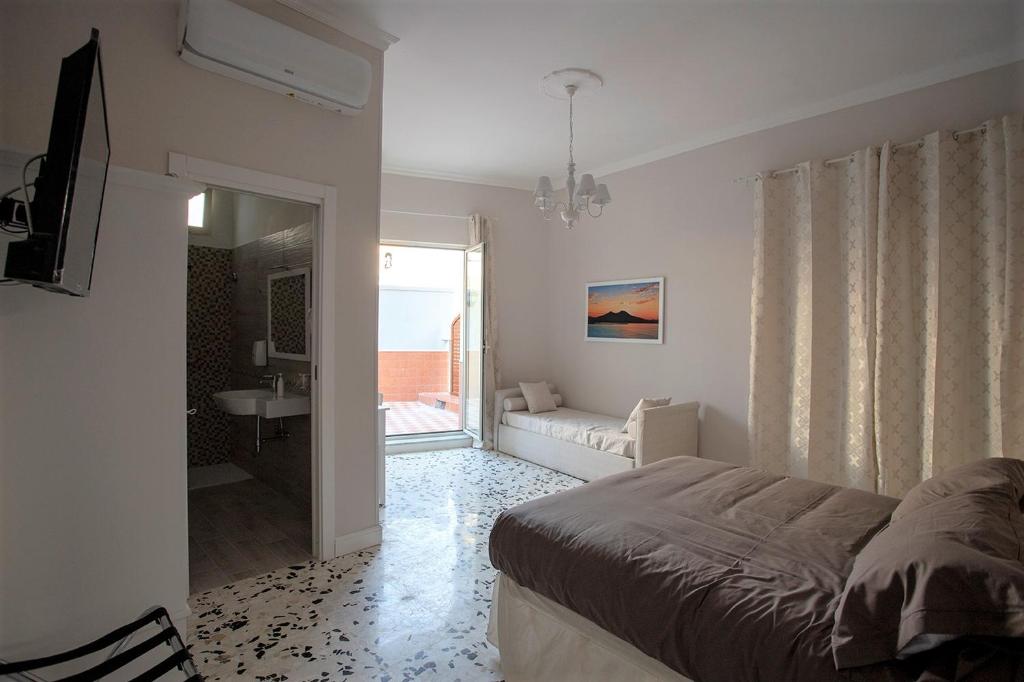 ein Schlafzimmer mit einem Bett und ein Wohnzimmer in der Unterkunft Agorà Mura Greche B&b in Neapel