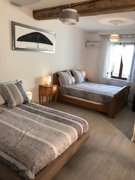 a bedroom with two beds and a table at Chambre Familiale du Couvent in Narbonne