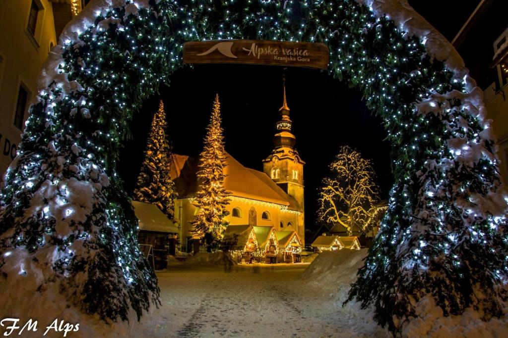 an archway with christmas lights in front of a building at Apartments Demec in Kranjska Gora