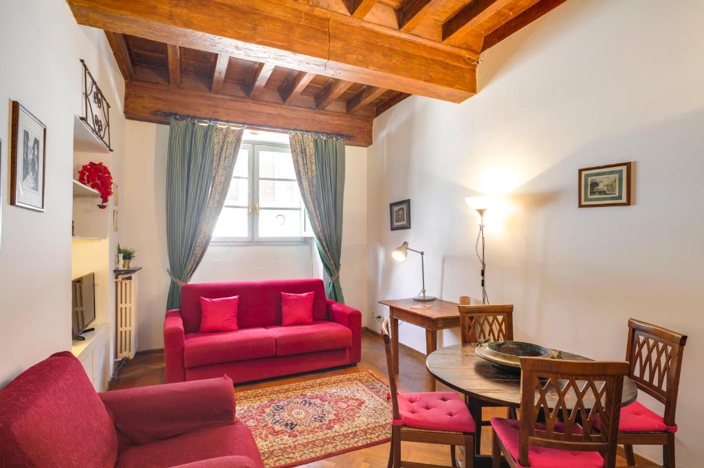 uma sala de estar com um sofá vermelho e uma mesa em Mamo Florence - Palazzo Spinelli Apartment em Florença