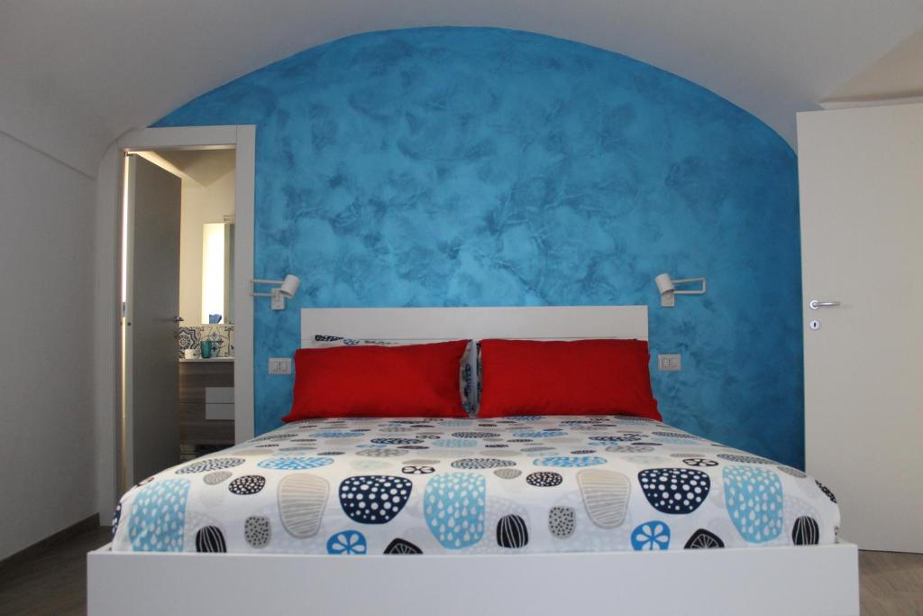 a bedroom with a large bed with a blue wall at La Casetta di Anna in Capri