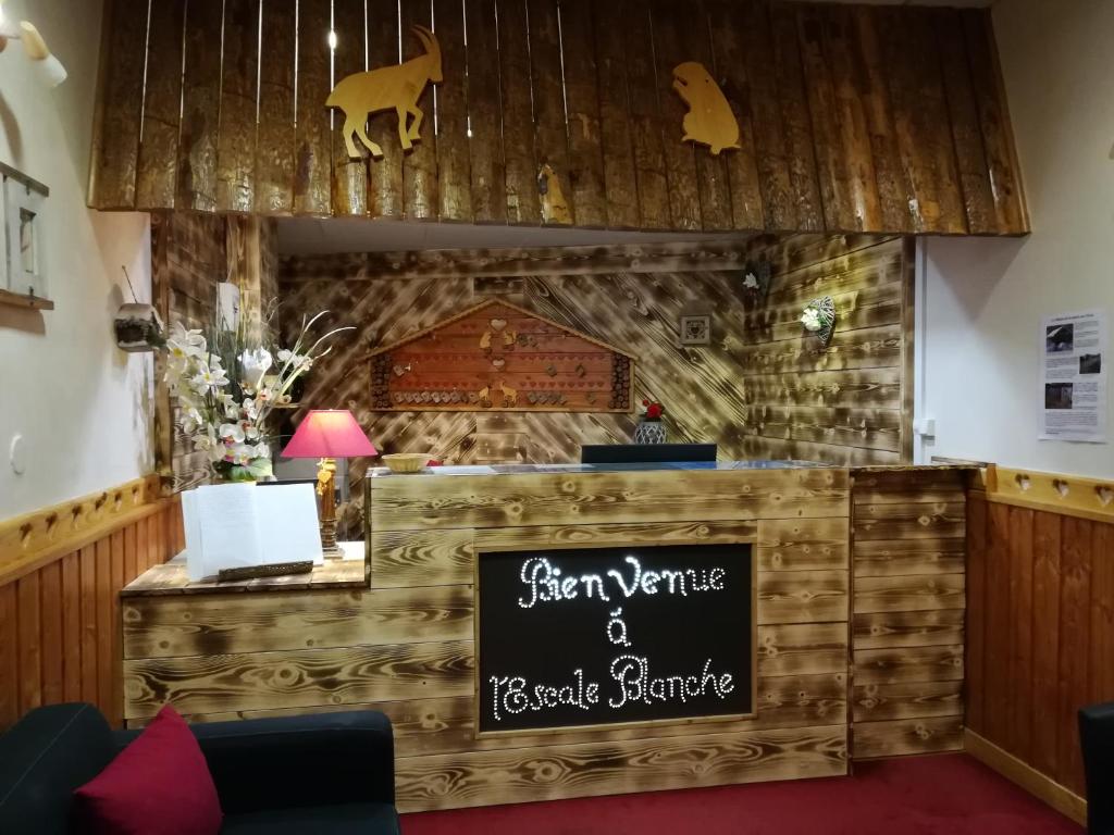 um restaurante com um cartaz que diz fazenda e bar de resgate em Hôtel L'Escale Blanche em Les Orres