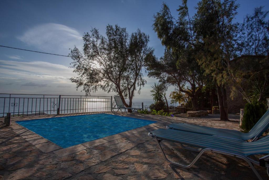 a swimming pool with a bench next to ahaps at Argyros house in Triopetra