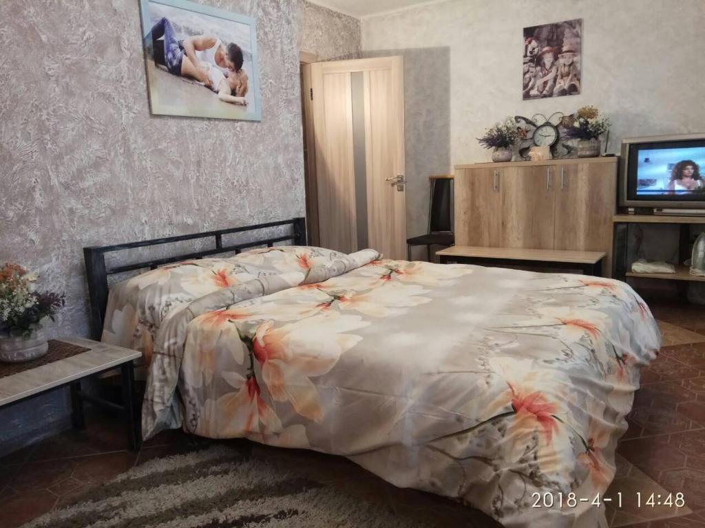 una camera da letto con un letto con un piumone di Apartment on Sobornaya 58 a Chmel'nyc'kyj