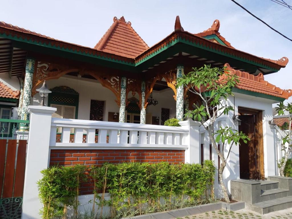 uma casa com uma cerca branca em frente em Rumah Jawa Guest House (Syariah) em Yogyakarta