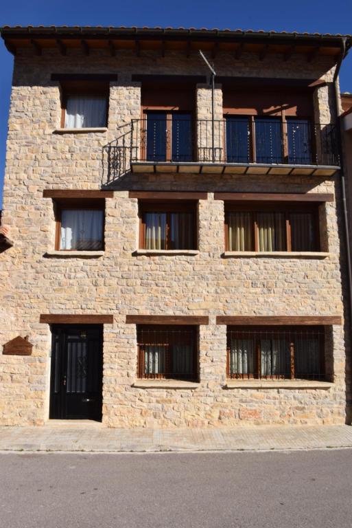 a brick building with windows and a balcony at Casa Mercedes in Villafranca del Cid