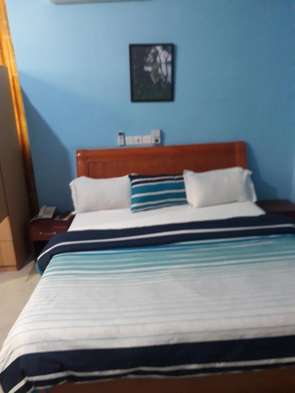 um quarto azul com uma cama grande e paredes azuis em Dreamers Lodge em Prampram