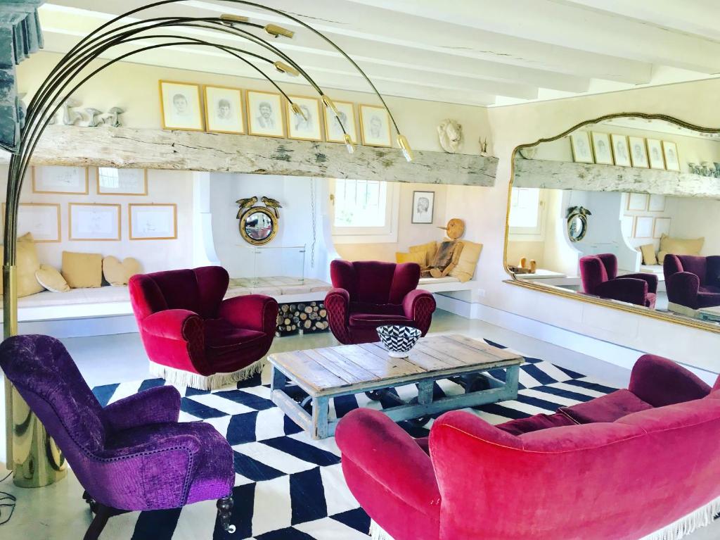 sala de estar con sillas de color púrpura y mesa en B&B Cà Bianca dell'Abbadessa en San Lazzaro di Savena