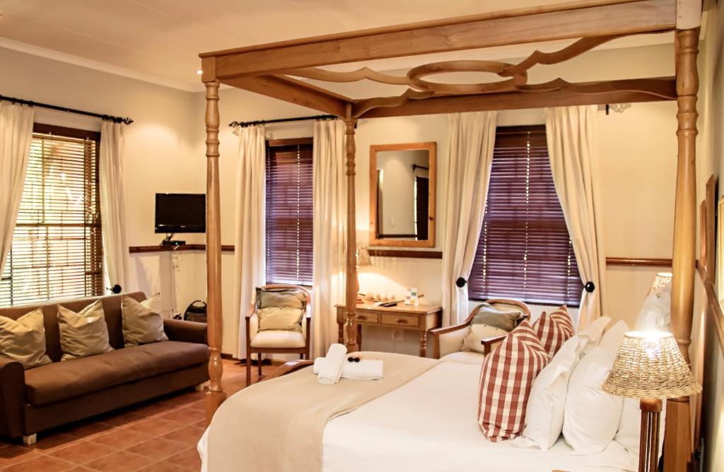 博福特西的住宿－Beaufort Manor Country Lodge，一间带天蓬床的卧室和一间客厅