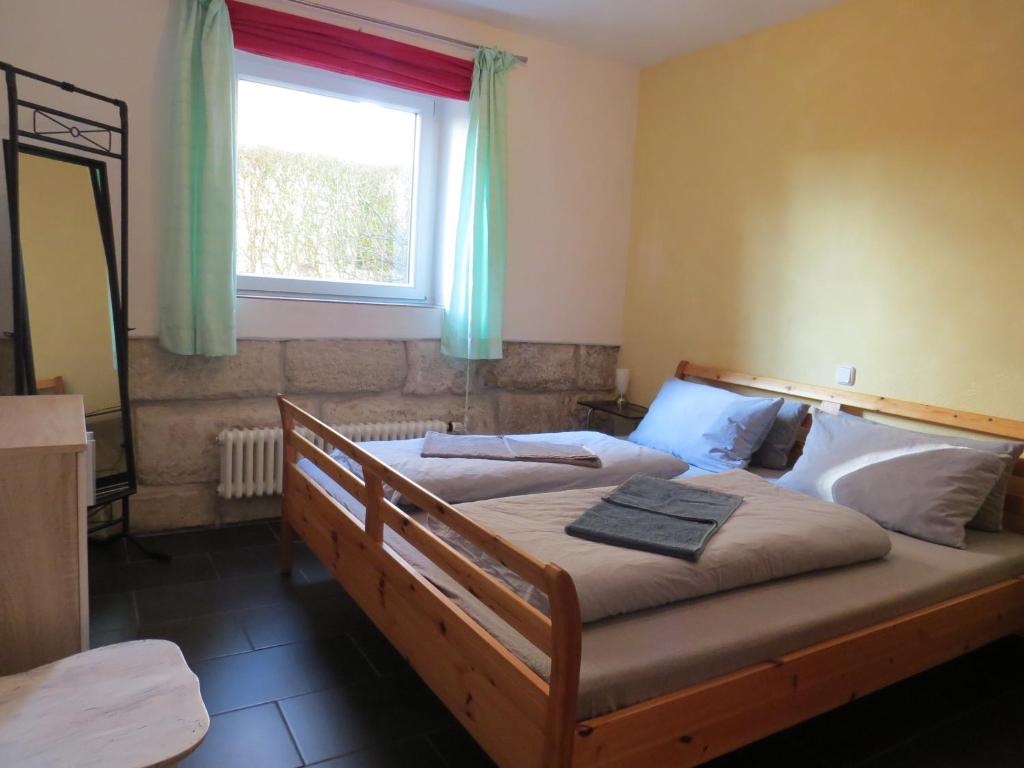 a bedroom with two beds and a window and a mirror at Ferienwohnung am Barbarossasee in Göppingen