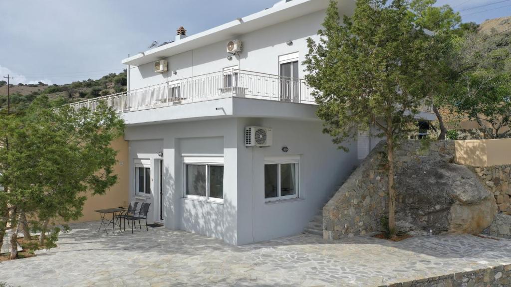 a white house with a balcony on top of it at Skouros Villa in Kastrí