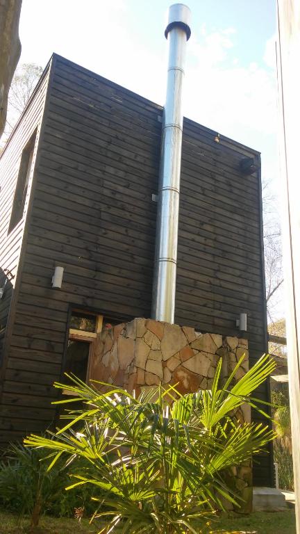 a house with a chimney and a plant in front of it at Resiliencia in Punta del Este