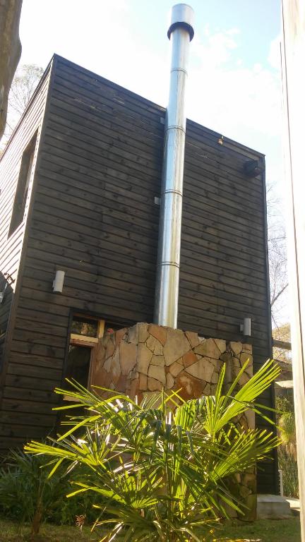 una casa con chimenea y una planta delante de ella en Resiliencia, en Punta del Este