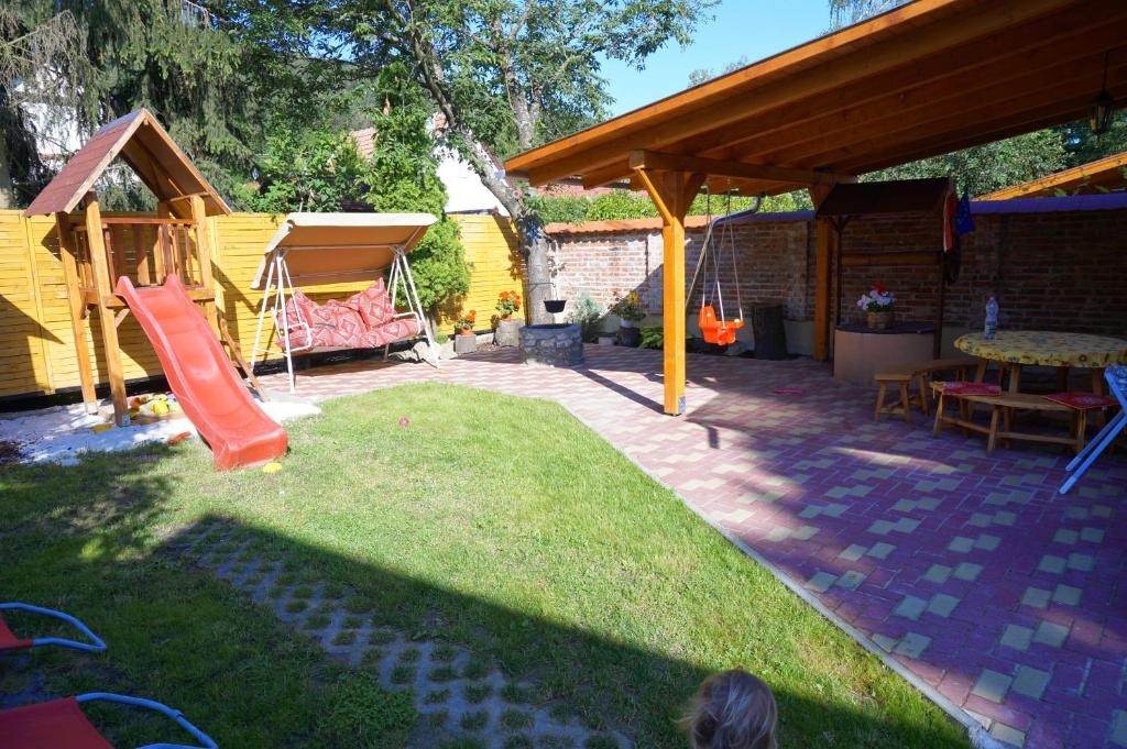 un patio trasero con un parque infantil con un tobogán en Best Holiday, en Bogács