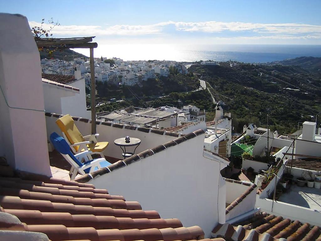 a balcony with chairs and a view of a city at Beach and Mountains in Frigiliana