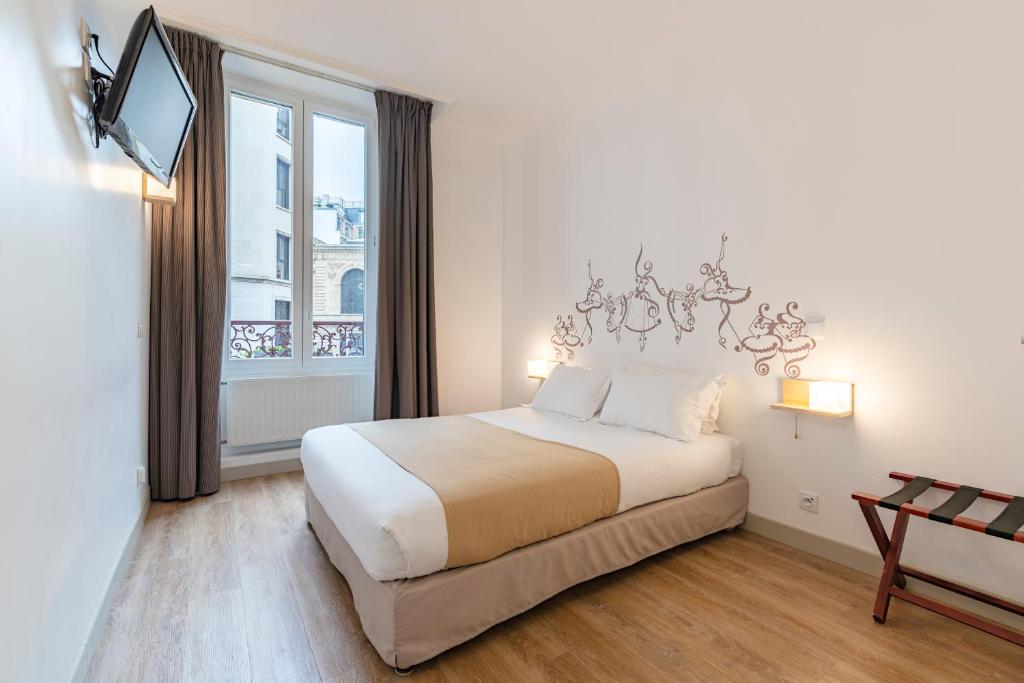 
a bedroom with a white bed and white walls at Korner Opera in Paris
