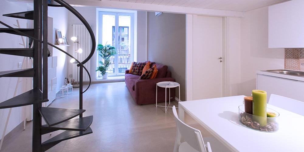 a kitchen and a living room with a table and a spiral staircase at SpAsimoH-2 in Palermo