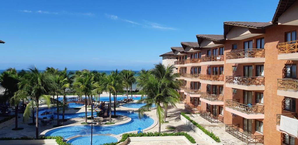 uma vista aérea de um resort com uma piscina e palmeiras em Manacá Apartamentos , Kariri Beach , Cumbuco em Cumbuco
