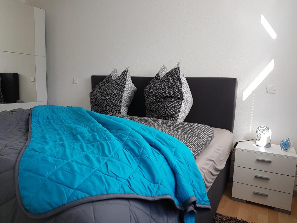 a bedroom with a blue comforter on a bed at Ferienwohnung Wössner in Oberndorf