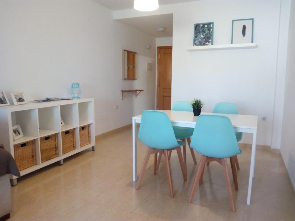 モンコファにあるEl apartamento de Marina en Moncofar playaのダイニングルーム(テーブル、青い椅子付)