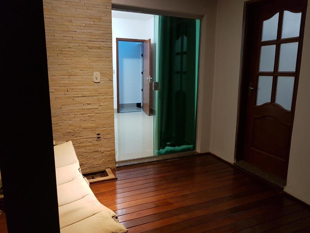 a room with a door and a wooden floor at Quarto com Varanda - Recanto do Sabiá in Campinas