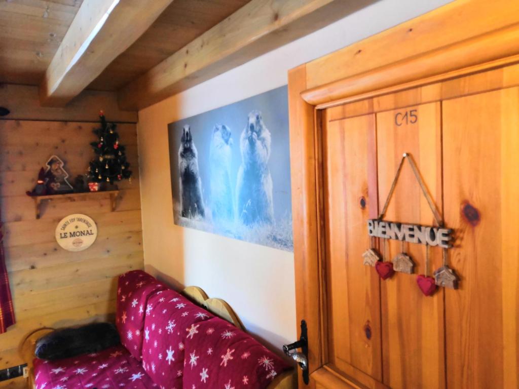 a living room with a red couch and a wall at Le Refuge des Marmottes in Sainte-Foy-Tarentaise