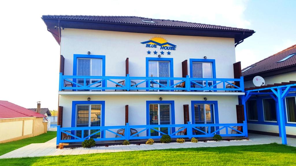 a blue and white building with a balcony at Pensiunea Blue House in Murighiol
