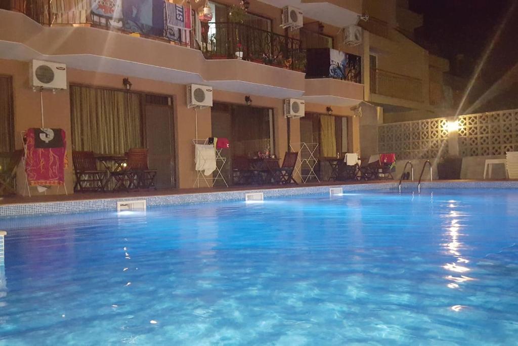 a large swimming pool at a hotel at night at Park and pool Studio Apostolovi in Nesebar