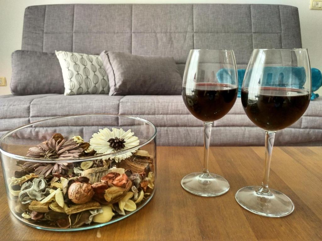 フロンテーラにあるApartamentos Isoraのワイン2杯、テーブルの上に盛り付けられた料理