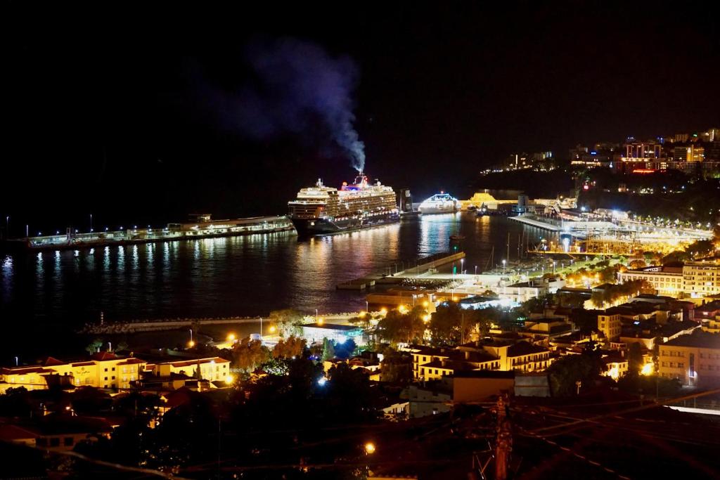 フンシャルにあるHappy House Madeiraの二隻の船が水中に浮かぶ夜の都市