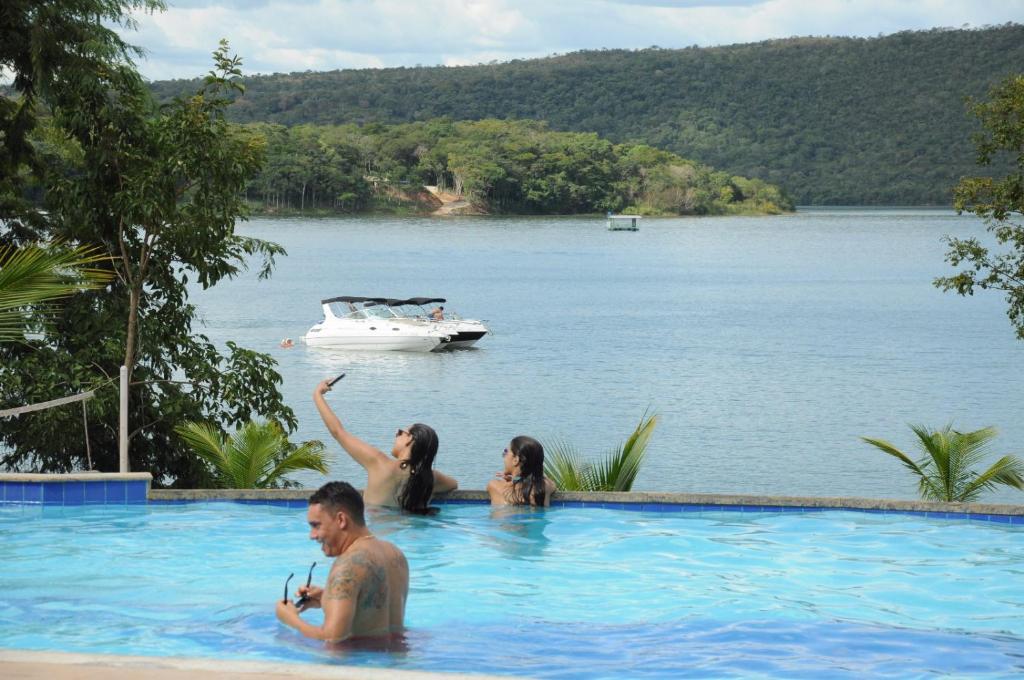 a group of people in a swimming pool in the water at Aldeia do Lago C104- Churrasqueira, bebidas liberadas nas piscinas, internet no ap, rampa no lago, pesqueiro, carregador carro elétrico in Caldas Novas