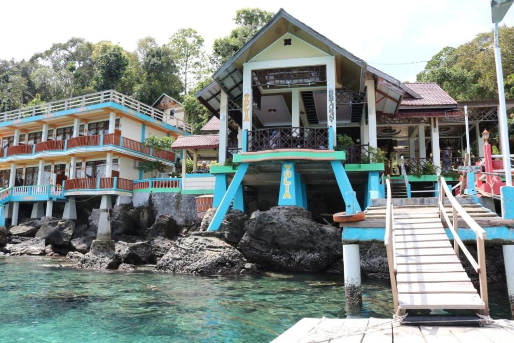 a house on the water next to a river at Yulia Resort in Sabong